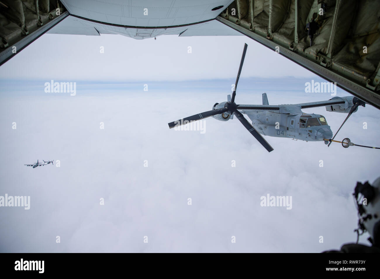 Naval aviators with Marine Medium Tiltrotor Squadron 262 (Reinforced) position an MV-22B Osprey tiltrotor aircraft during aerial refueling with a KC-130J Super Hercules from Marine Aerial Refueler Transport Squadron (VMGR) 152 off the coast of Japan, Feb. 28, 2019. U.S. Marines with VMGR-152 provide a wide range of capabilities throughout the INDOPACOM area to include aerial refueling, personnel and cargo transportation, and aerial delivery. (U.S. Marine Corps photo by Lance Cpl. Tyler Harmon) Stock Photo