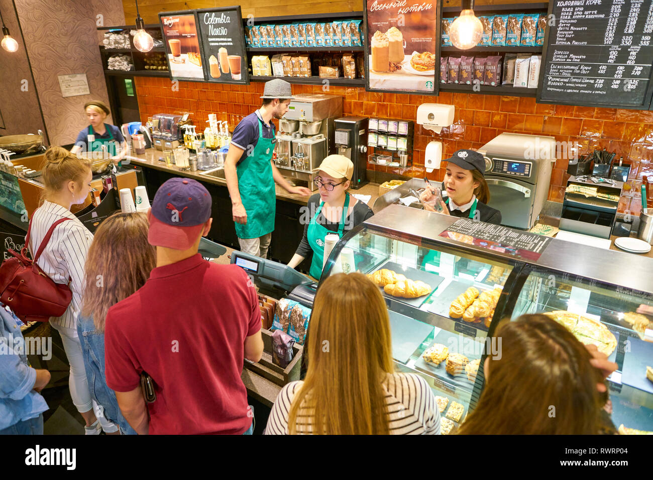 MOSCOW, RUSSIA - CIRCA OCTOBER, 2018: people staying in queue at counter service a Starbucks coffeeshop. Stock Photo