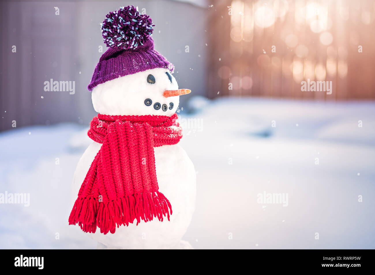 Smiling snowman with purple hat and red scarf Stock Photo