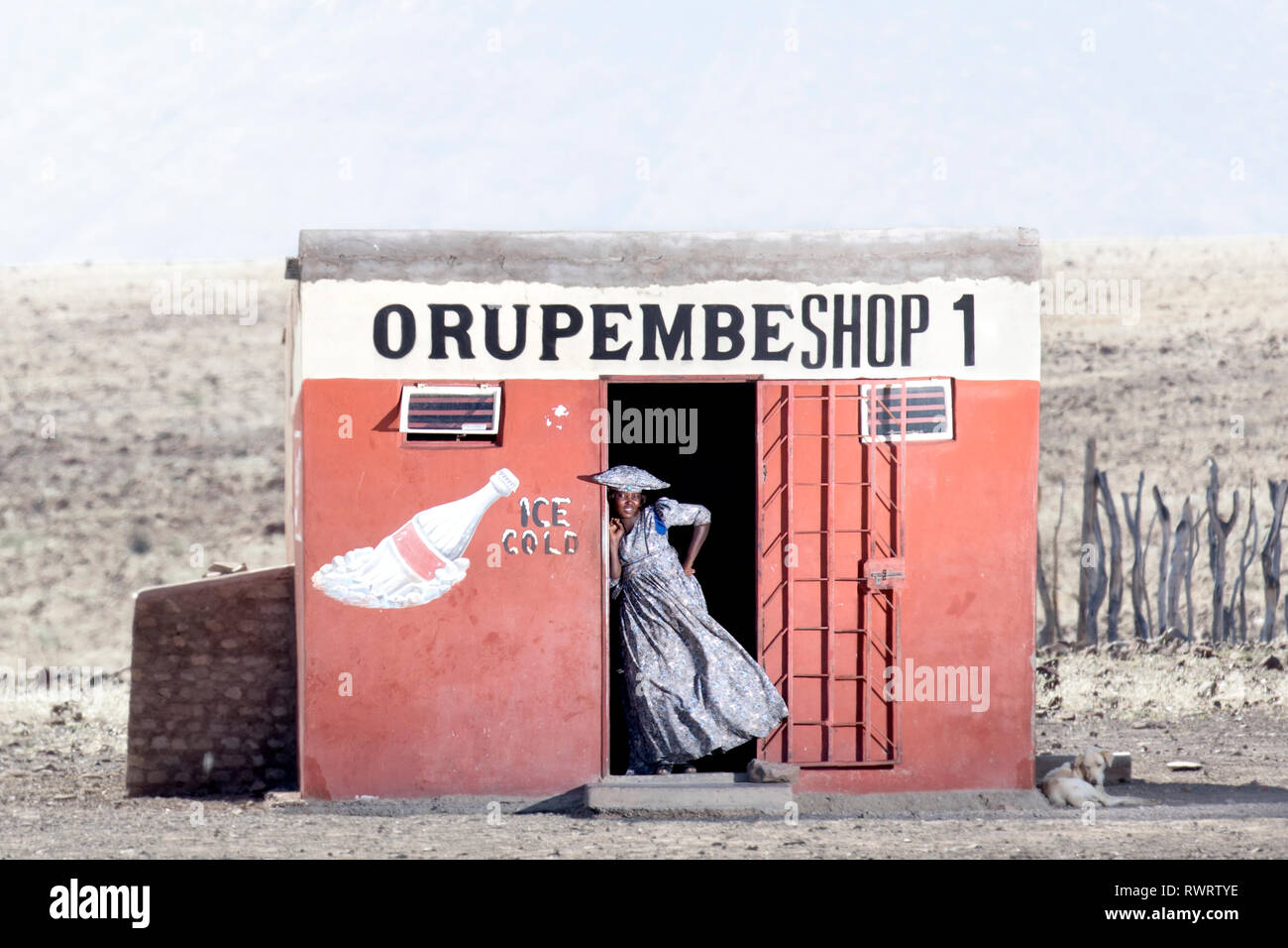 A Herero woman by a shop in the arid Kunene Region of northern Namibia. Stock Photo