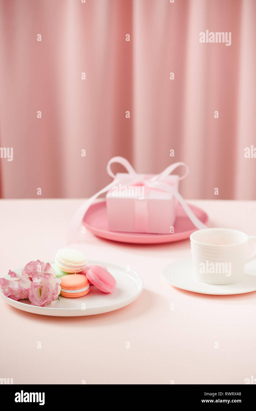 https://c8.alamy.com/comp/RWRX48/happy-womanmothers-day-image-of-a-coffee-or-tea-cup-and-lisianthus-flower-with-macaroon-and-gifts-beside-on-drapes-of-pink-RWRX48.jpg