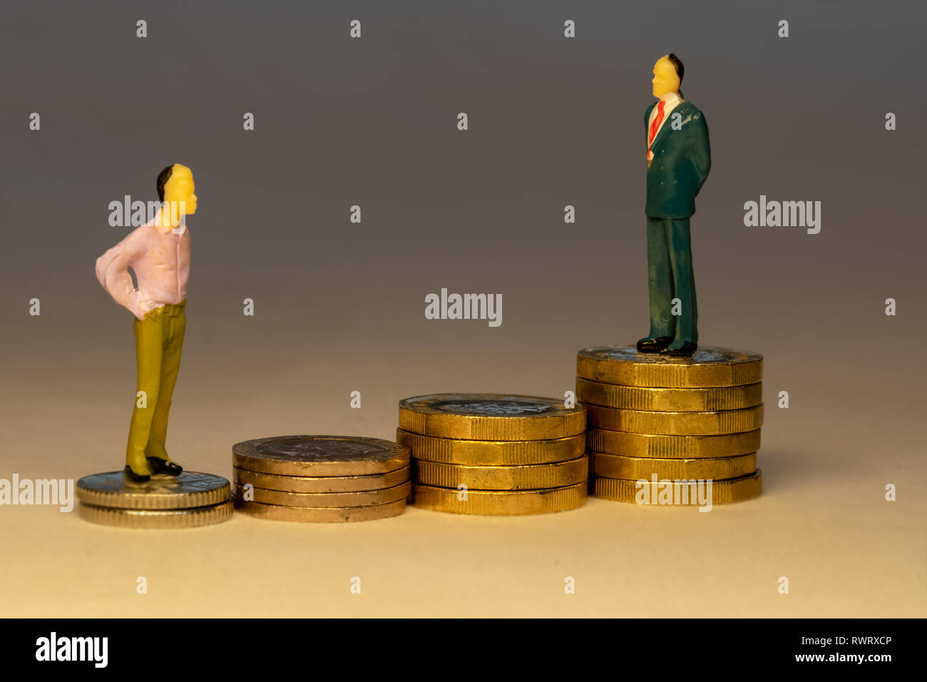 Man looking to business man standing on top of increasing piles of gold coins. Business career concept. Stock Photo