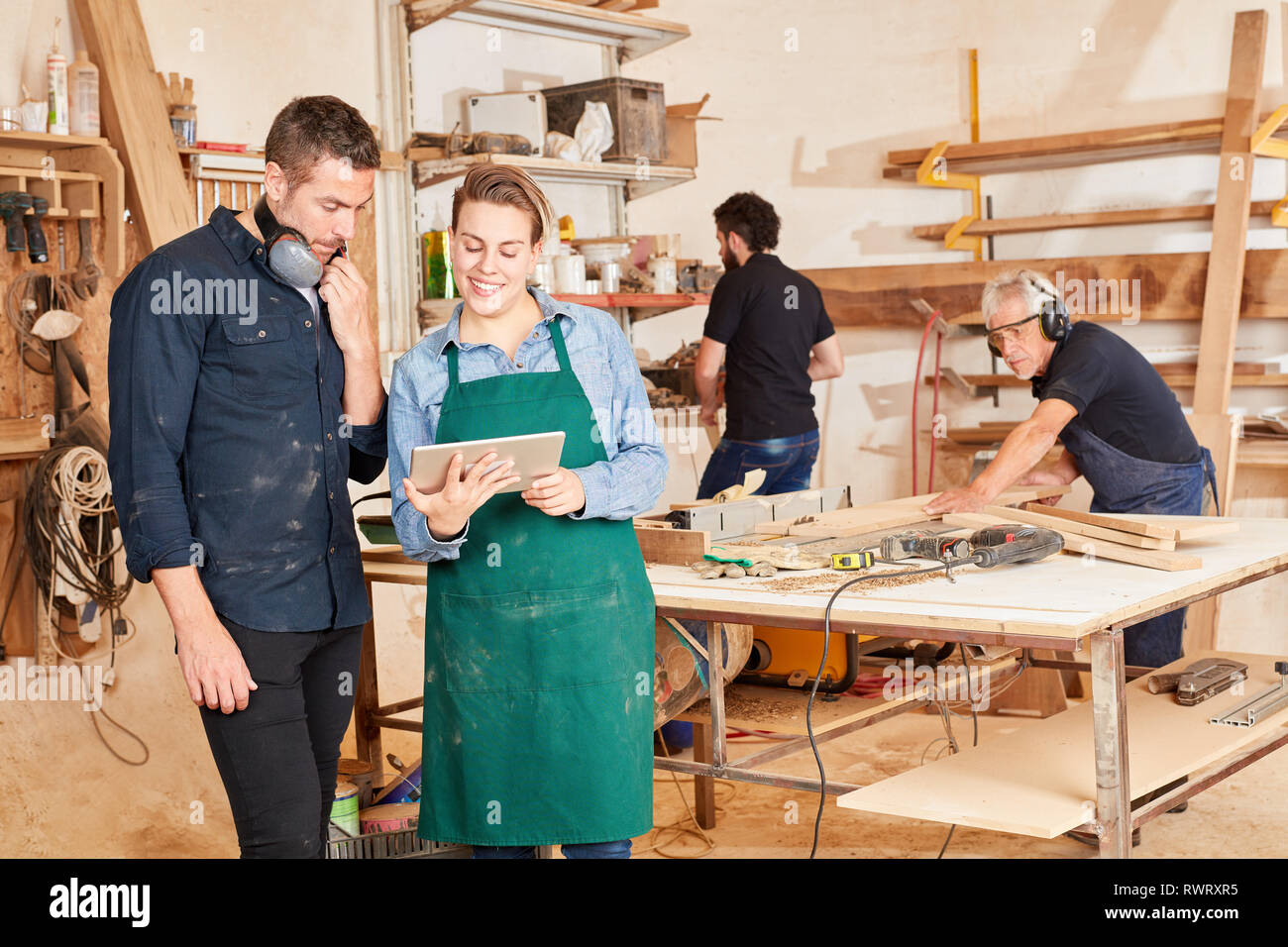 Young craftsman using tablet computer online in joinery workshop Stock Photo