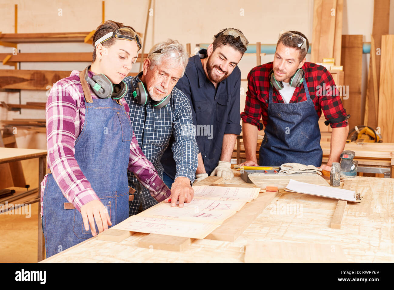 Woman as a trainee in joiner training together with master and colleagues Stock Photo