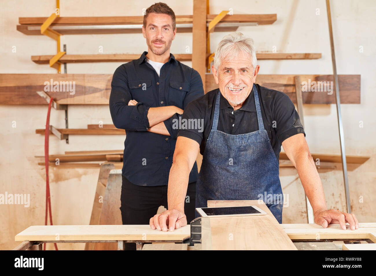 Experienced carpenter master and apprentice together in the carpentry Stock Photo Alamy