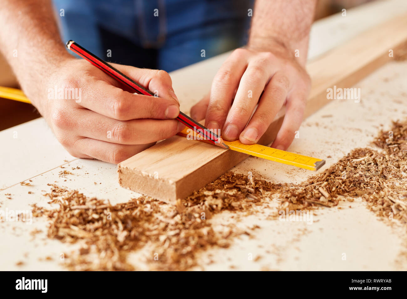 Craftsman with folding rule and pencil at the wood measuring in the workshop Stock Photo