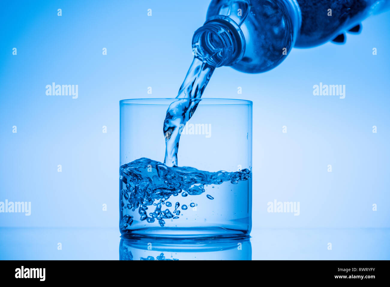 https://c8.alamy.com/comp/RWRYFY/cropped-view-of-man-pouring-water-from-plastic-bottle-in-glass-on-blue-background-RWRYFY.jpg