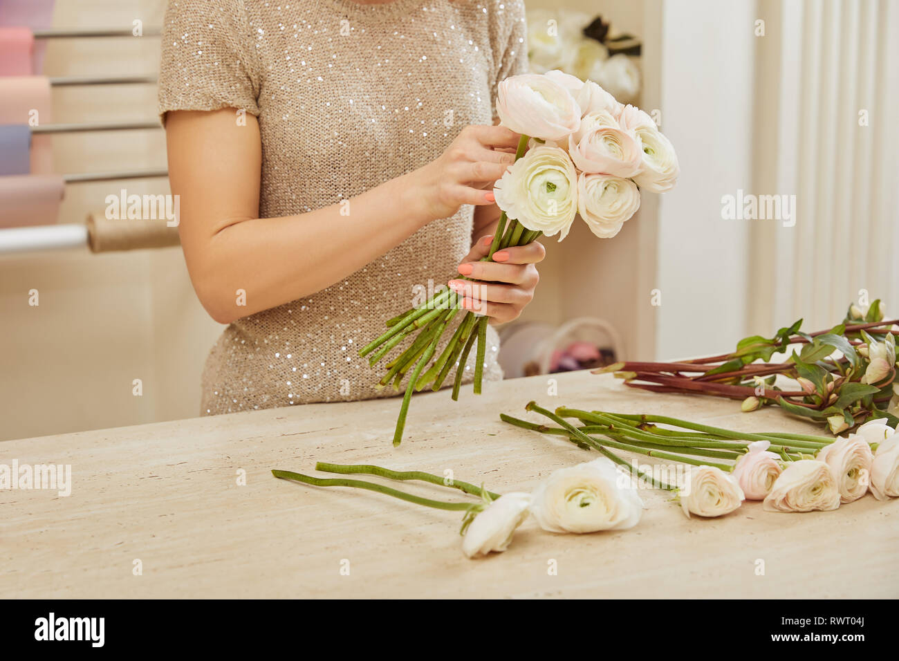 partial view of florist making bouquet of white peonies at workplace ...