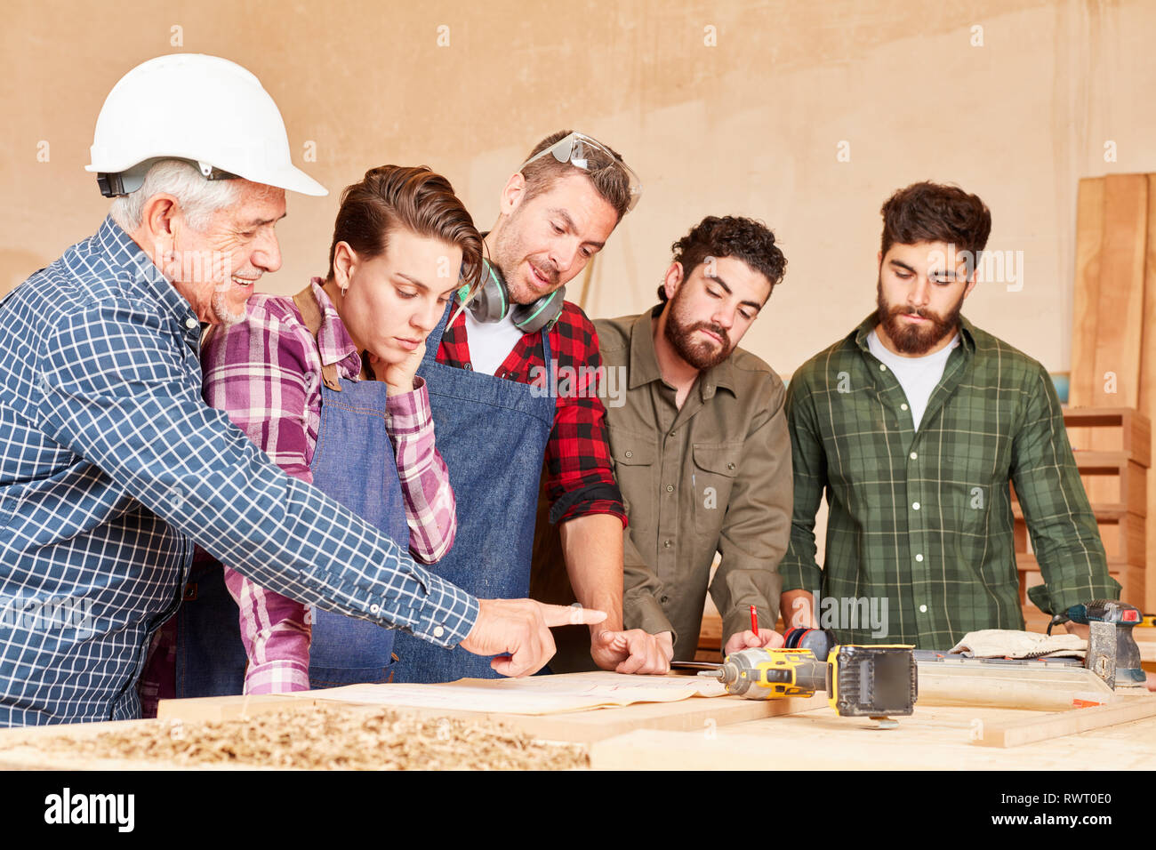 Craftsman team with masters and apprentices at a construction project meeting Stock Photo