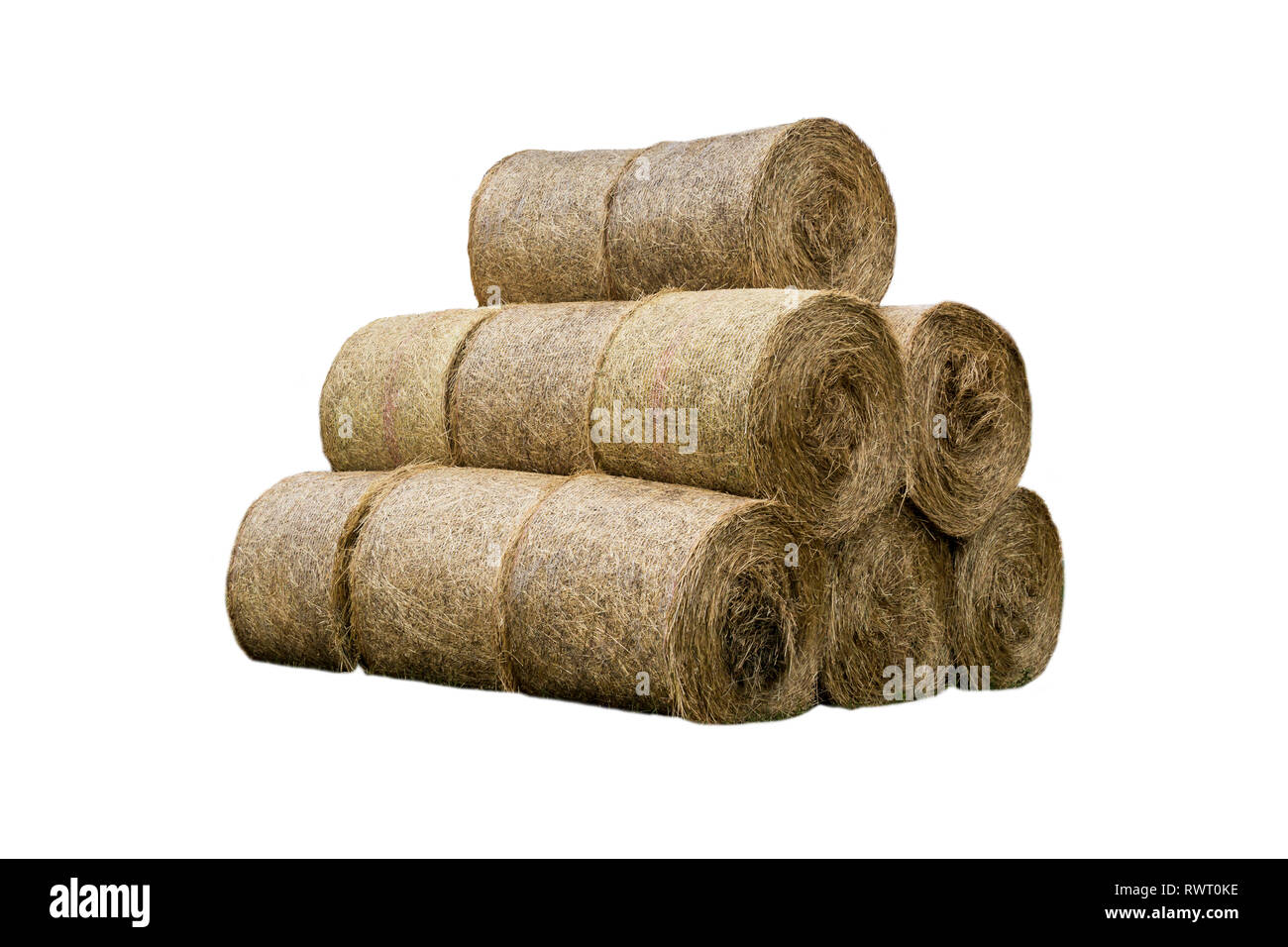 Stacked like a pyramid, bales of straw, tightened mesh . Feed and bedding for livestock on a dairy farm. General view.  Isolated photo . Stock Photo