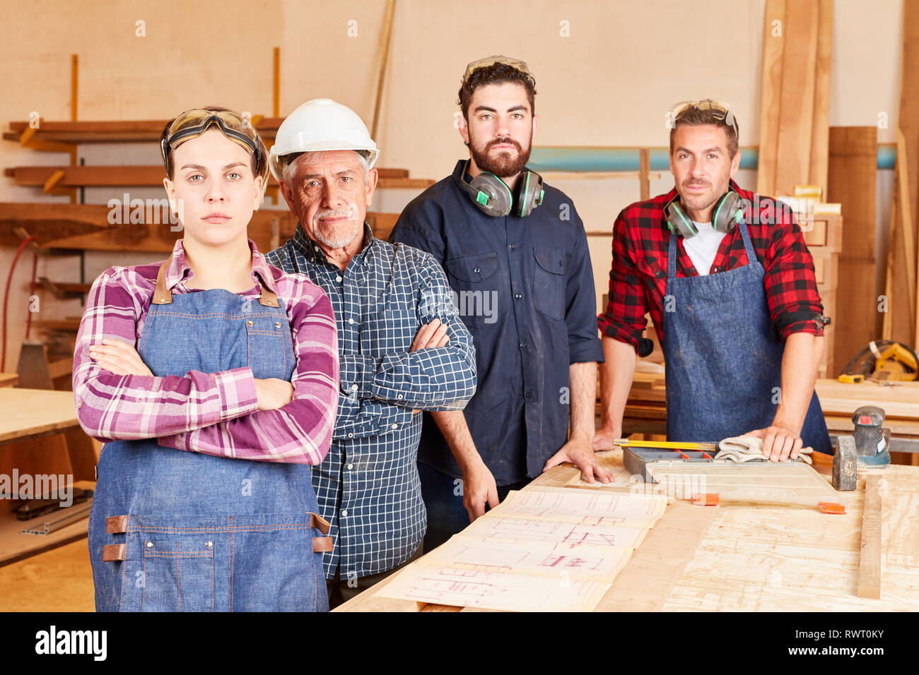 Self-assured craftsman Master and team with men and women as apprentice Stock Photo