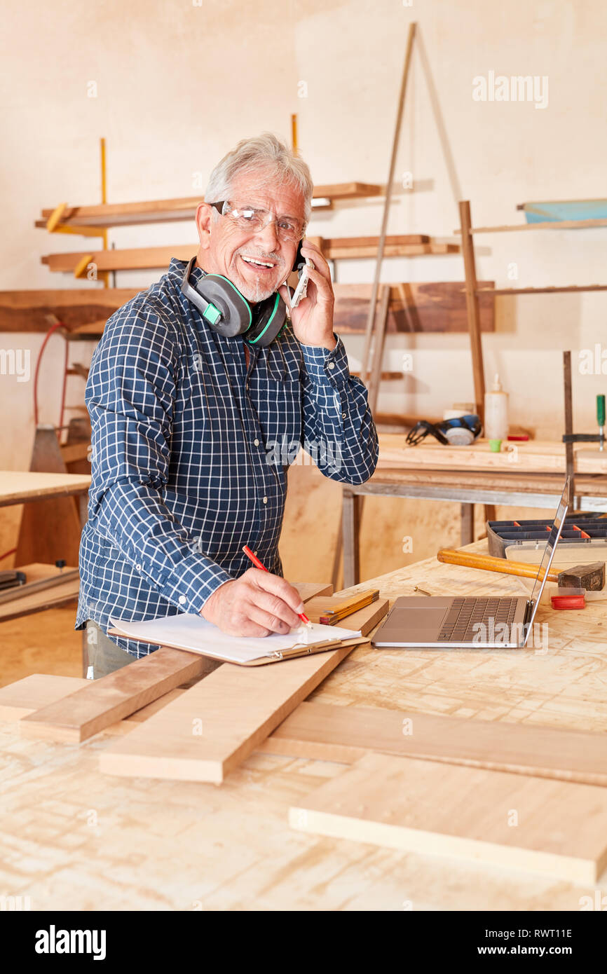 Old craftsman with mobile phone and checklist on the phone in customer