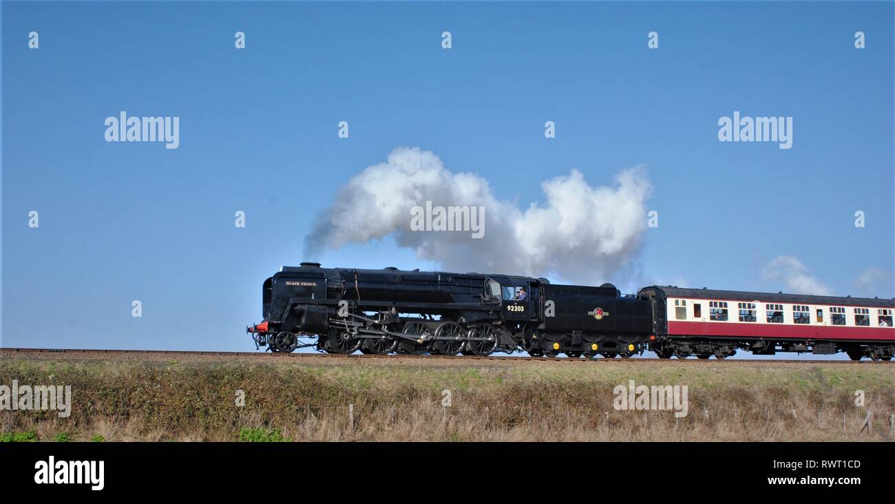 Black Prince, large black steam engine steaming through the countryside on a bright sunny day Stock Photo