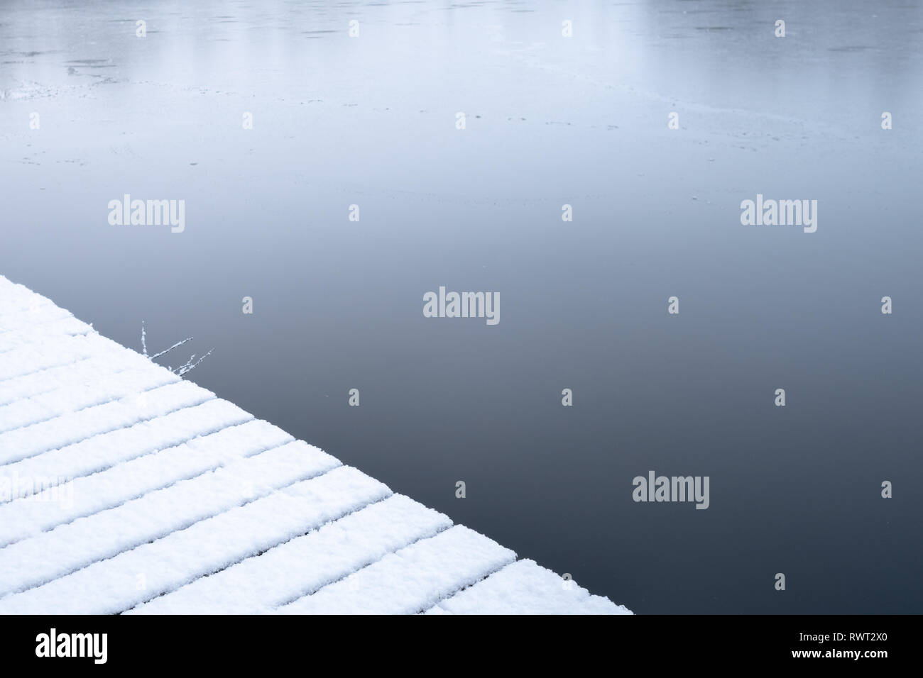 A snow covered jetty next to Crime Lake on a cold winter morning Stock Photo