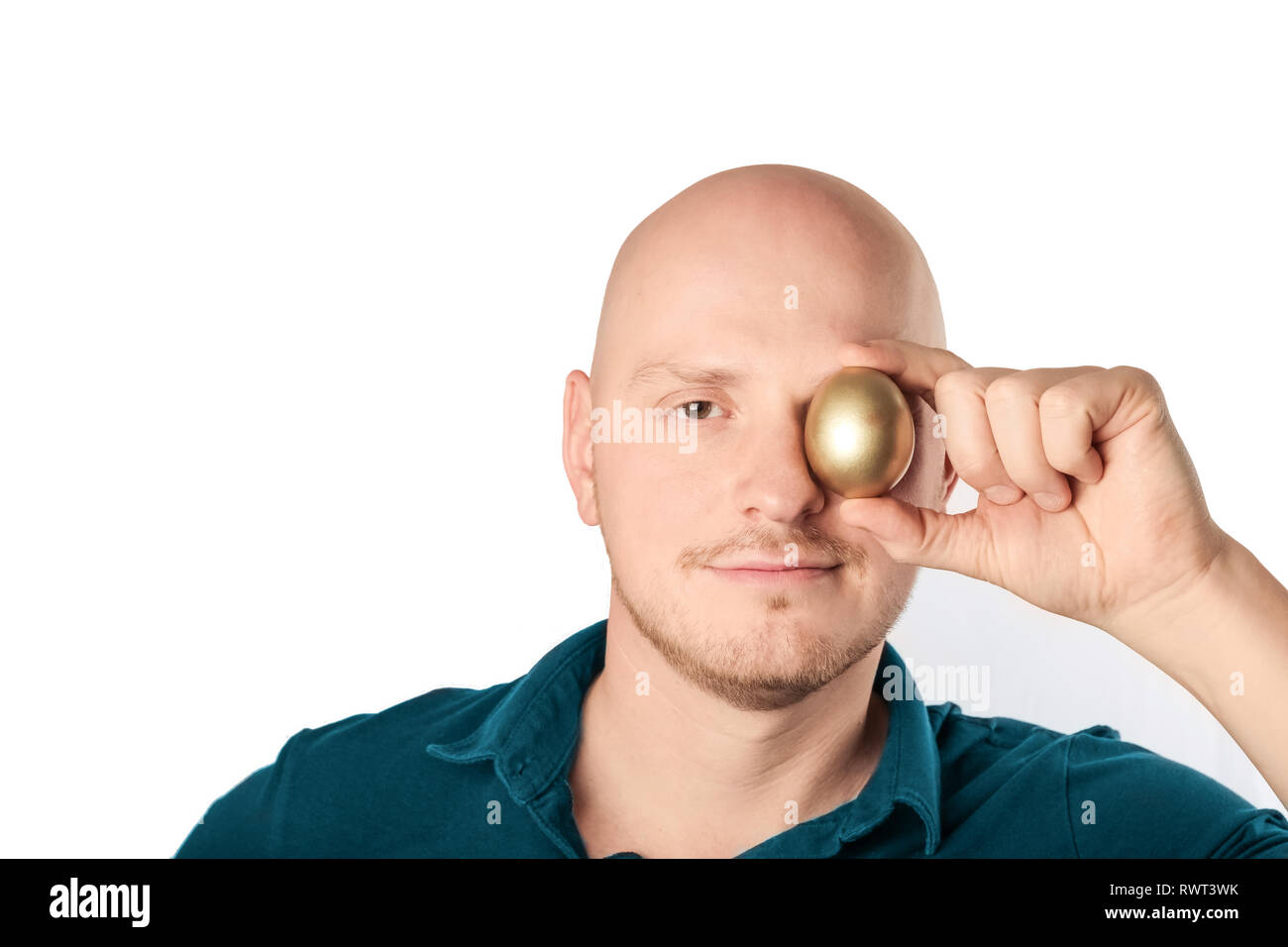 Young man with blue shirt holding golden egg to the camera, feeling confident., feeling confident. Studio shot on a white background Stock Photo