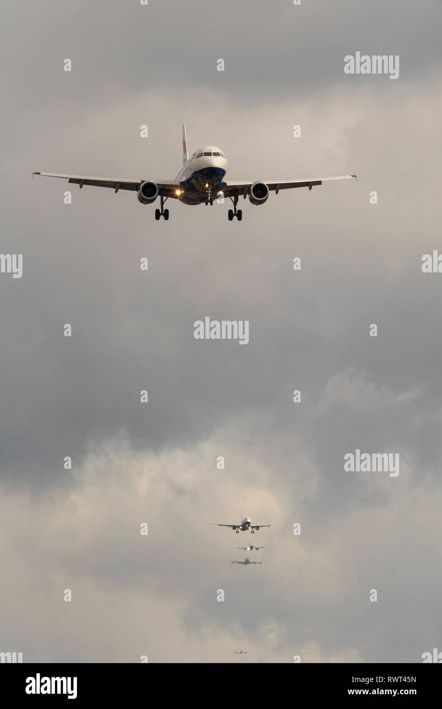 Queue of planes on final approach to land at London Heathrow Airport, London, UK. Landing airliners. Busy finals for landing at airport Stock Photo