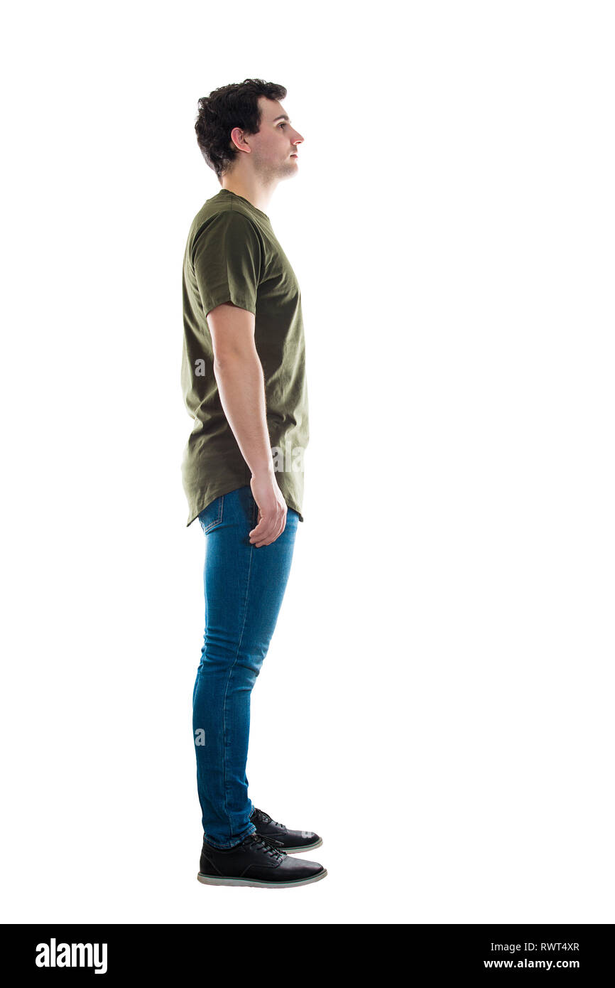 Full length side view of casual young man standing relaxed looking ahead isolated over white background. Stock Photo