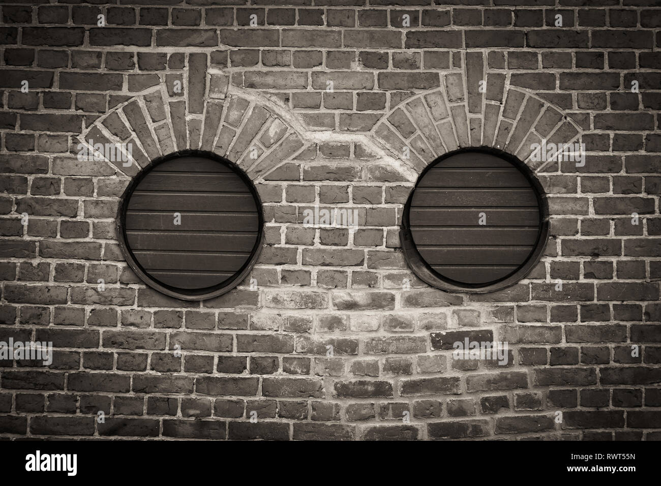 Two round holes in brick wall Stock Photo - Alamy