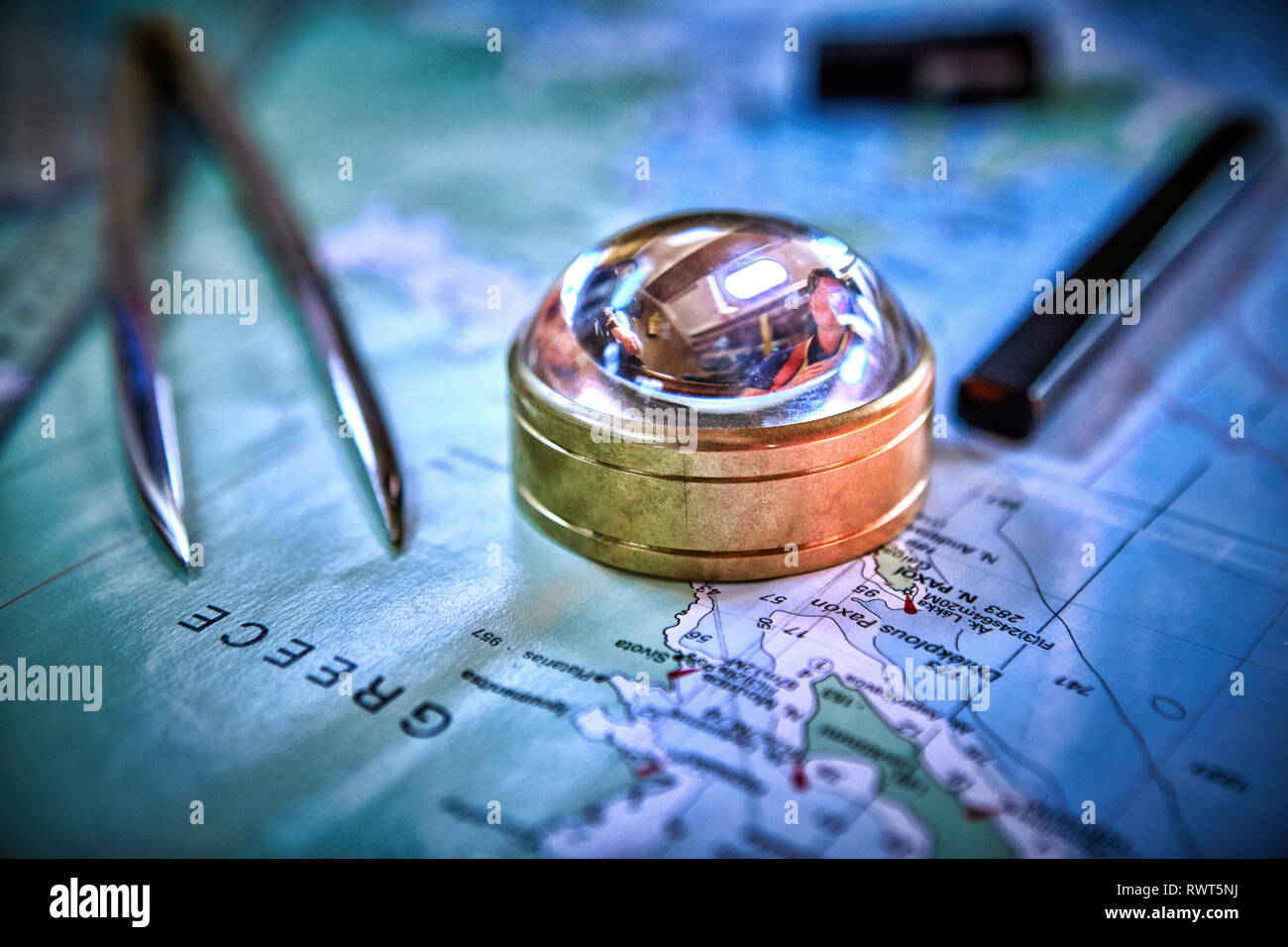 Magnetic compass and magnifying glass on map Stock Photo