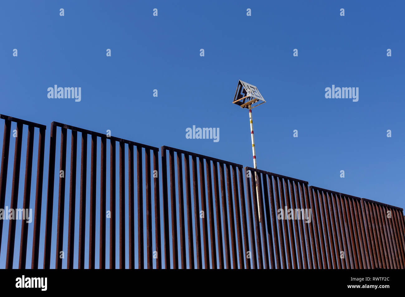 Detail view of early bollard fence made of round steel tubing, note location marker attached to top of fence, about 3 miles west of Nogales Arizona. Stock Photo