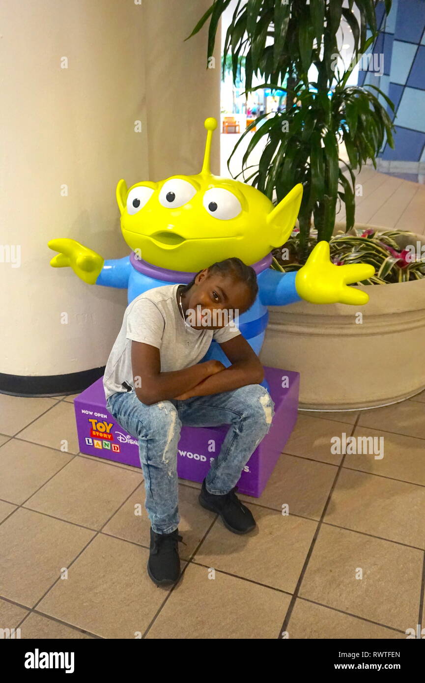 Young boy posing next to statue at Orlando International Airport, USA