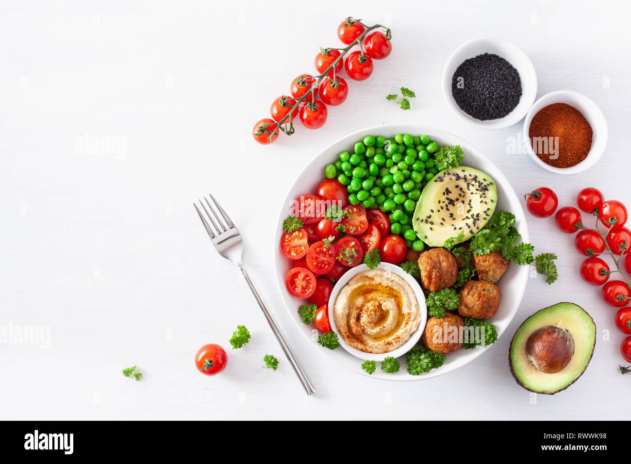 healthy vegan lunch bowl with falafel hummus tomato avocado peas Stock Photo