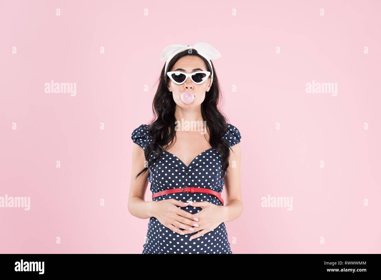 pregnant woman chewing bubble gum and touching belly isolated