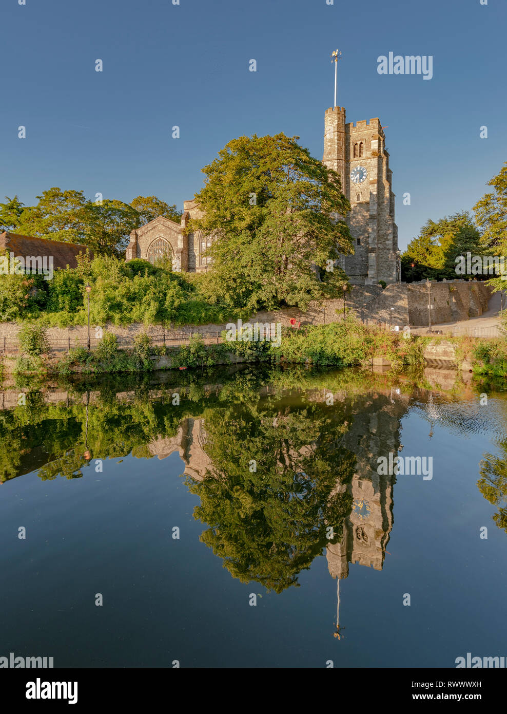 Views of The bishops palace and other notable buildings, Maidstone, kent reflected in the water to give near perfect symmetry. Blue sky, still water Stock Photo