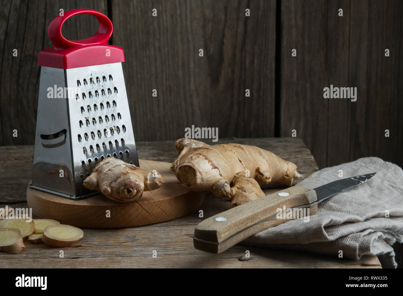 Ginger root and grater on kitchen table. Stock Photo