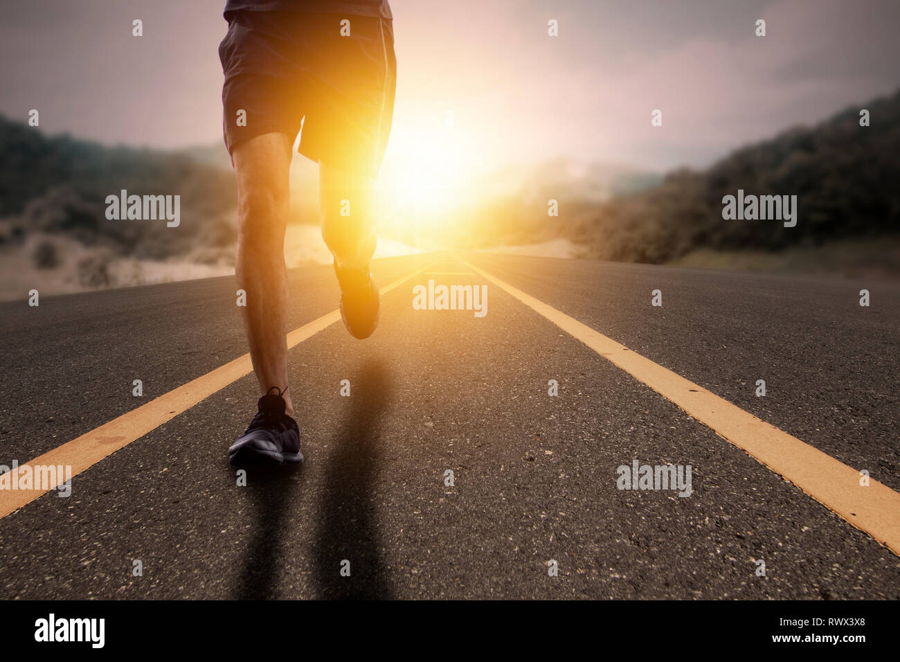 Goal and Strive concept, Runner run on road with sun rising. Stock Photo
