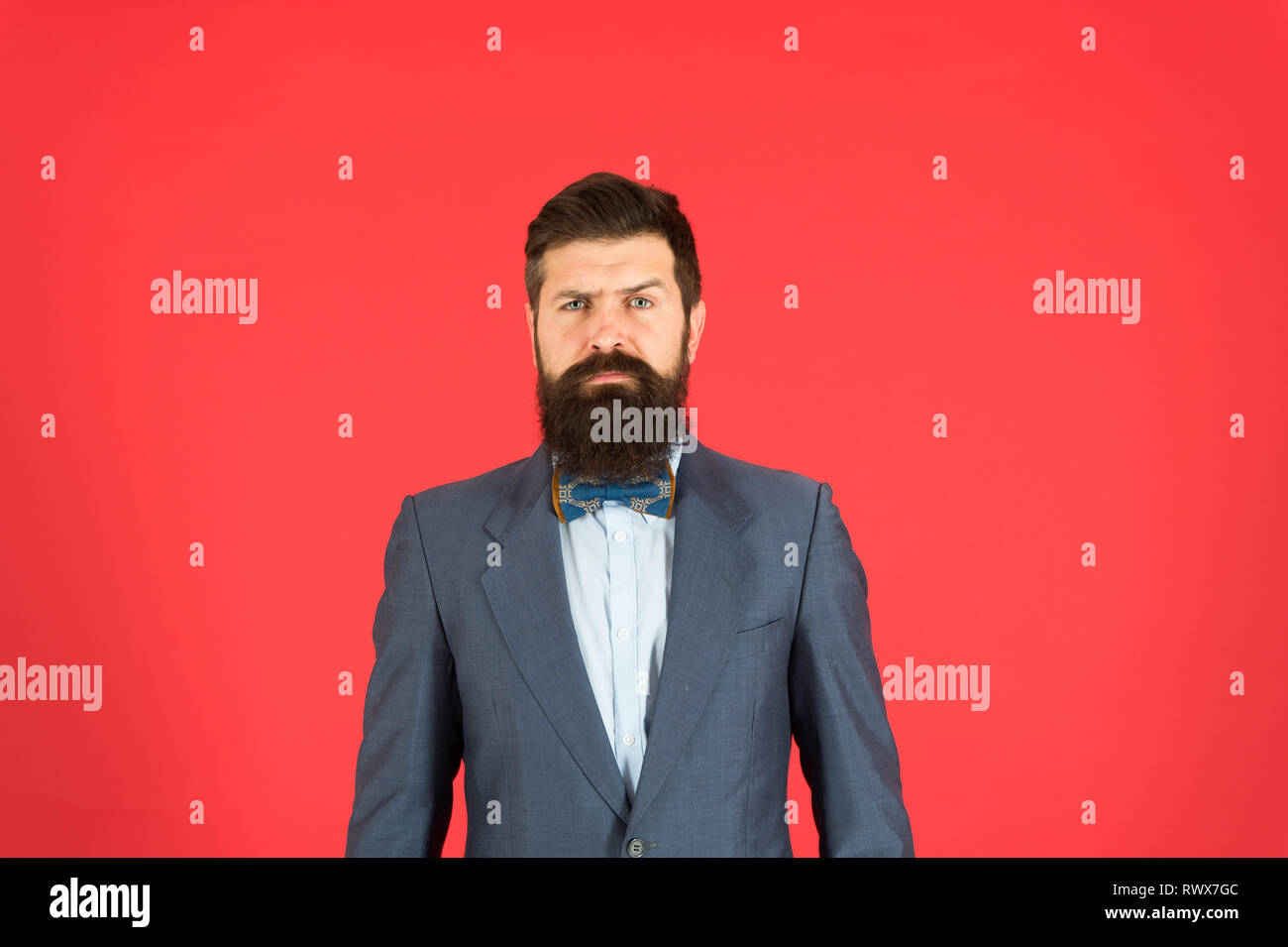 Classy style. Man bearded hipster wear classic suit outfit. Formal outfit.  Take good care of suit. Elegancy and male style. Businessman or host  fashionable outfit on red background. Fashion concept Stock Photo -