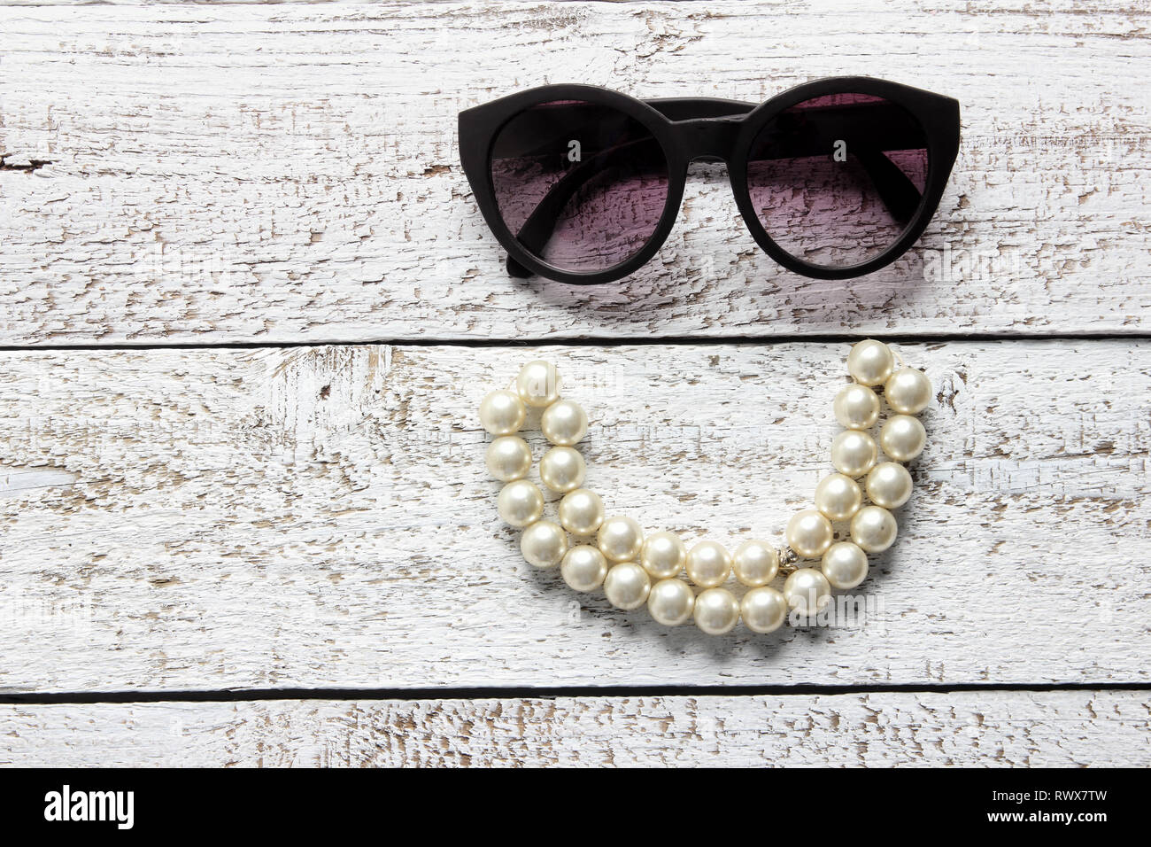 Sunglasses and Pearl Necklace on Wooden Background Stock Photo - Alamy