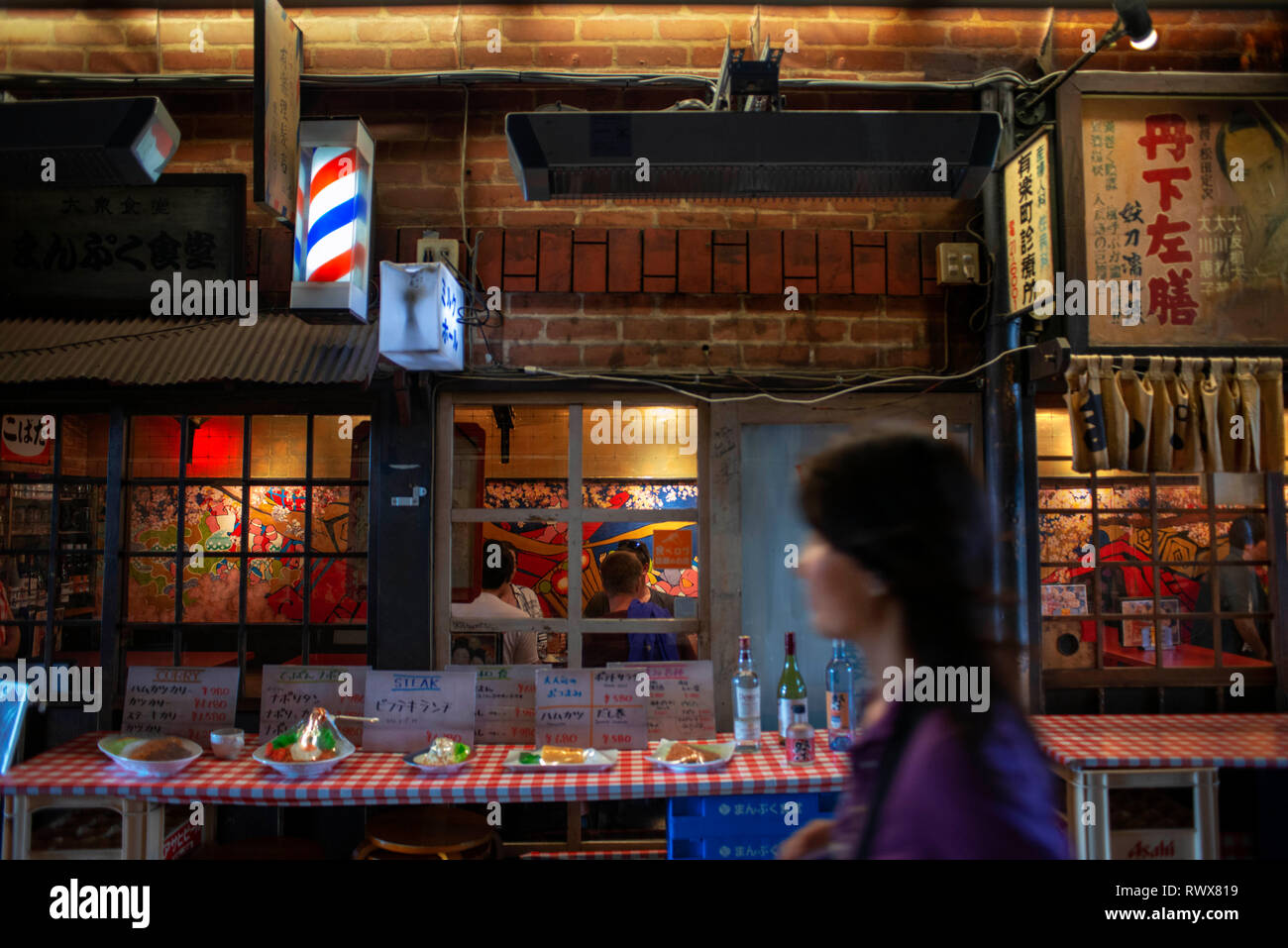 Dining under the train tracks: the Yakitori alley, Tokyo Japan. Located under the train tracks through which the famous bullet trains pass are this al Stock Photo