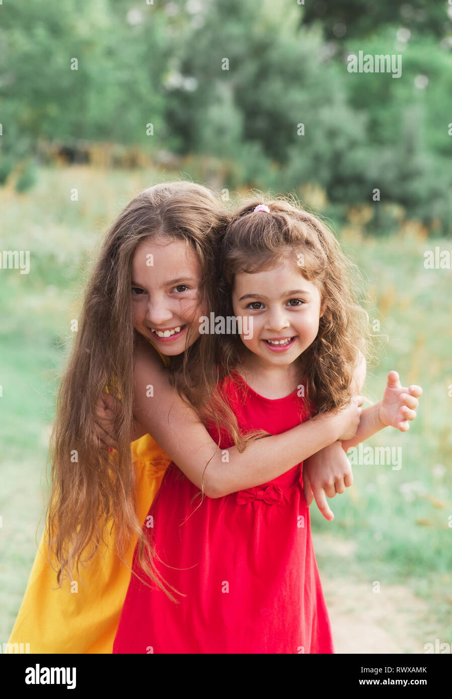 Portrait of Two Cute little girls embracing and laughing at the
