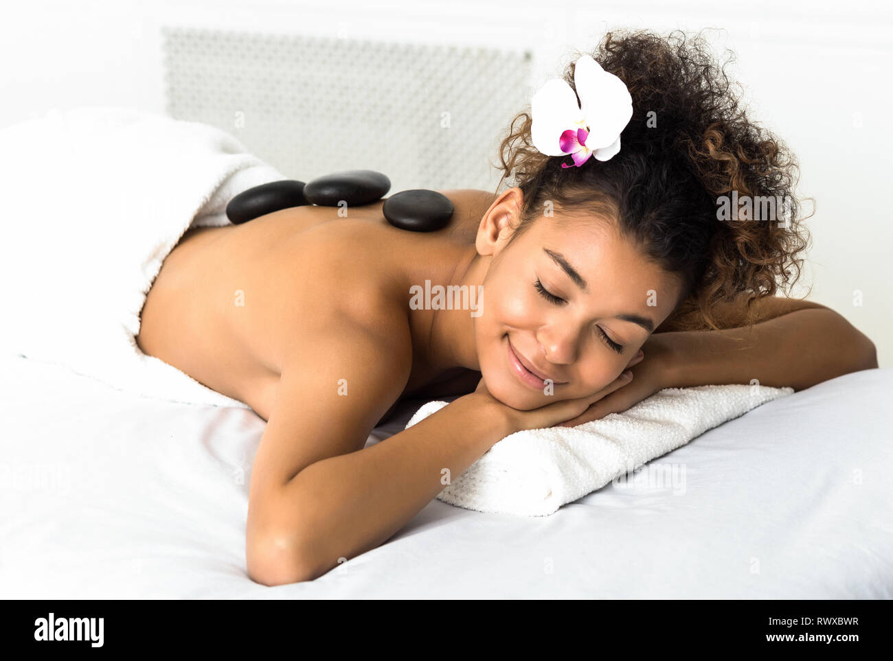 Stone massage. Woman relaxing at spa salon Stock Photo