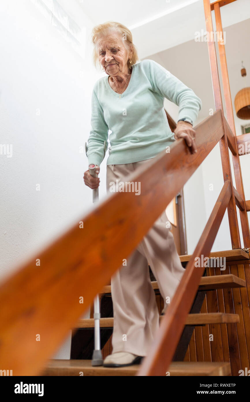 Elderly woman at home using a walking cane to get down the stairs Stock Photo Alamy