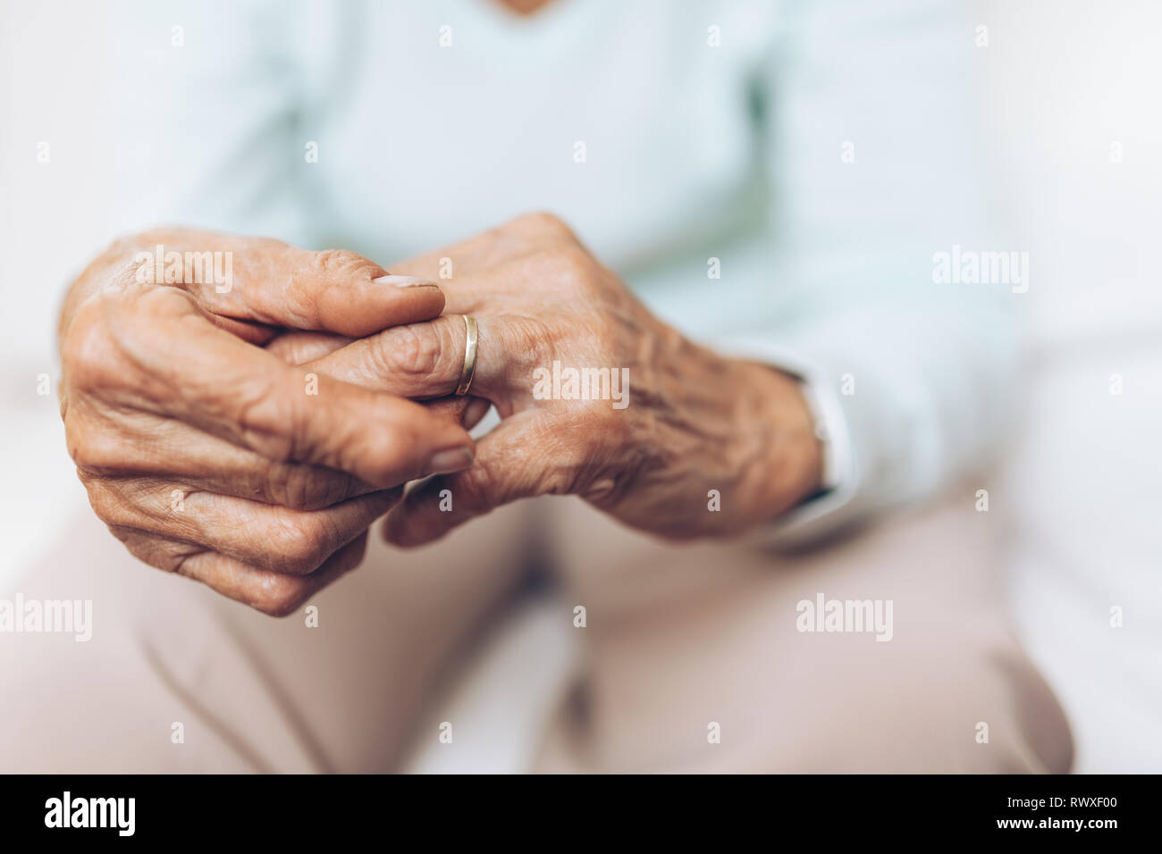 Heartbroken elderly woman holding he husbands wedding ring Stock Photo