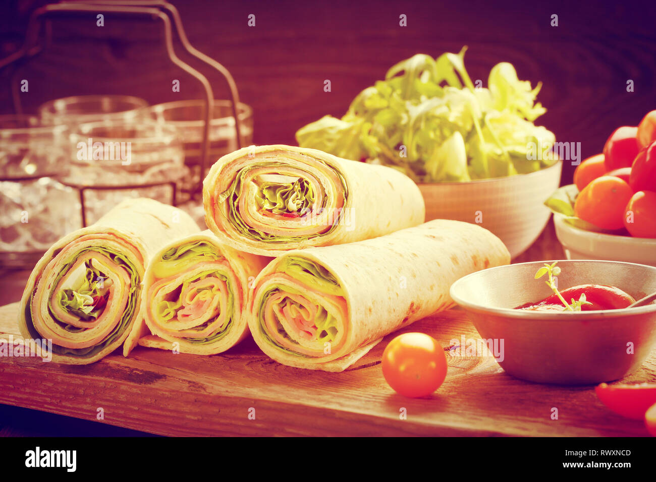 Tortilla wraps with ham cheese and vegetables, close up vintage view