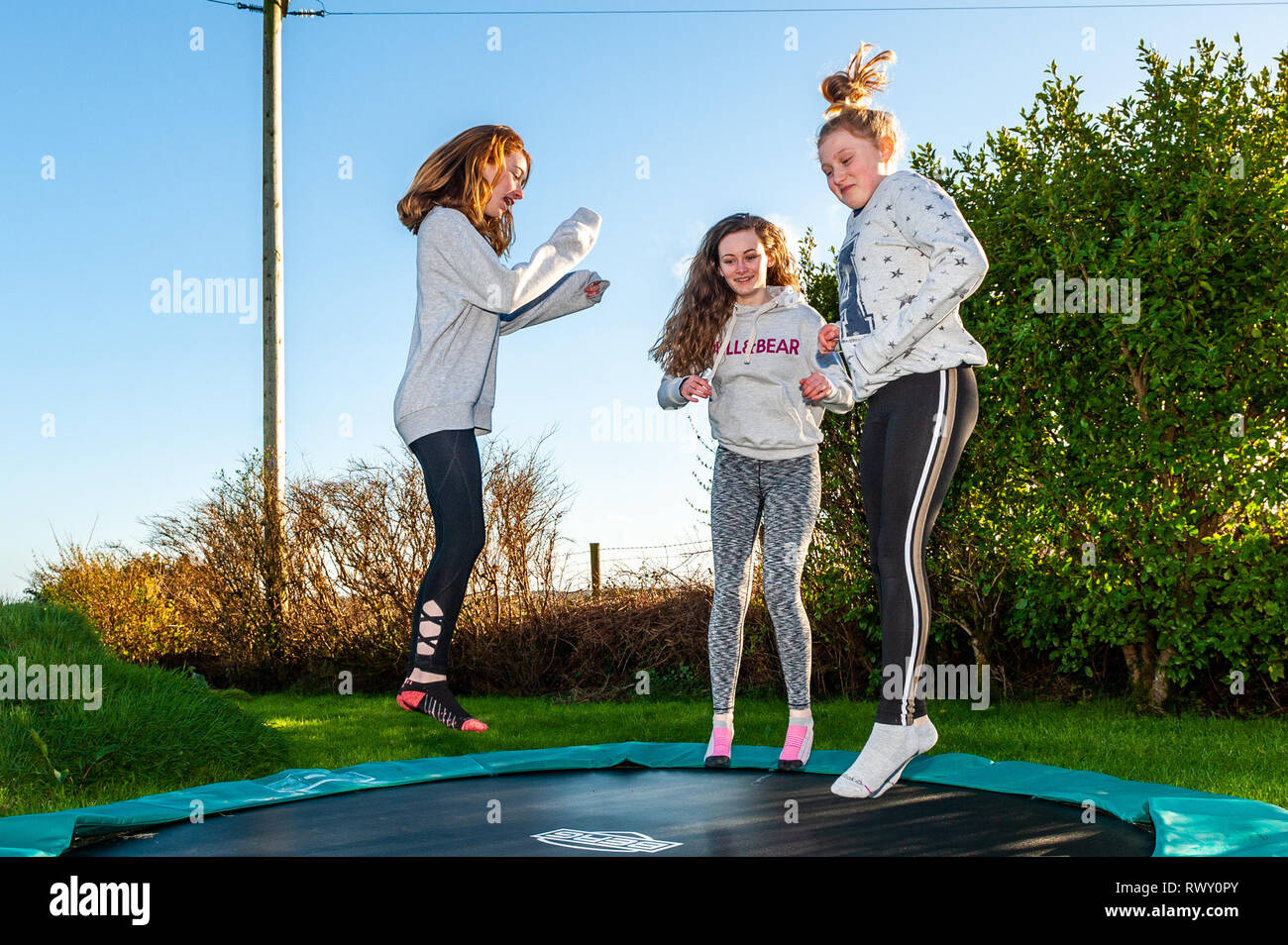 Ballydehob, West Cork, Ireland. 7th March, 2019. Girls make the most of the hot, sunny weather by bouncing on a trampoline. The day will continue to be sunny whilst tomorrow will start off dry with showers developing in the afternoon. Credit: AG News/Alamy Live News. Stock Photo