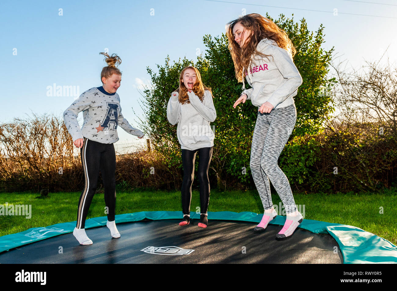 Ballydehob, West Cork, Ireland. 7th March, 2019. Girls make the most of the hot, sunny weather by bouncing on a trampoline. The day will continue to be sunny whilst tomorrow will start off dry with showers developing in the afternoon. Credit: AG News/Alamy Live News. Stock Photo