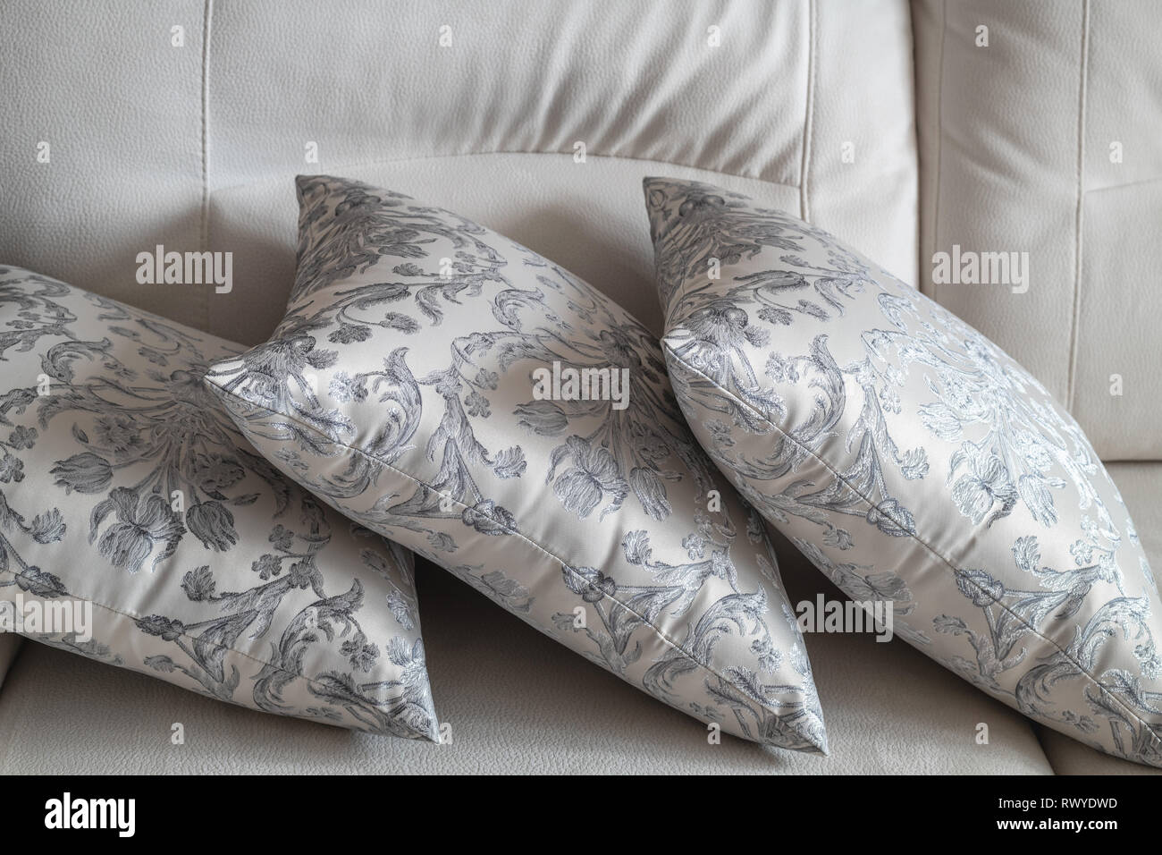 several patterned pillow on the light sofa Stock Photo