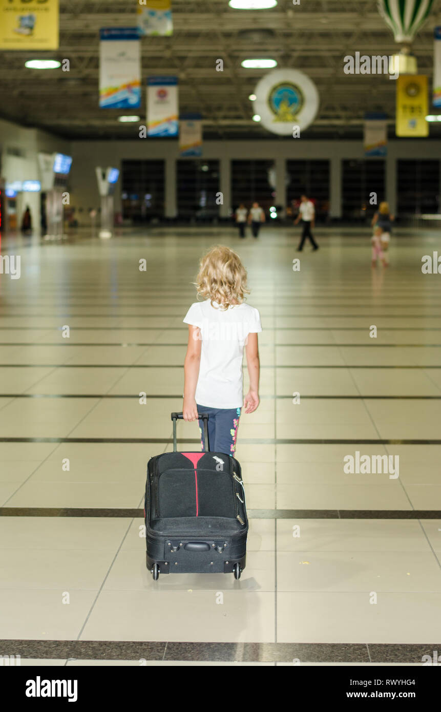 blond girl alone with suitcase Stock Photo