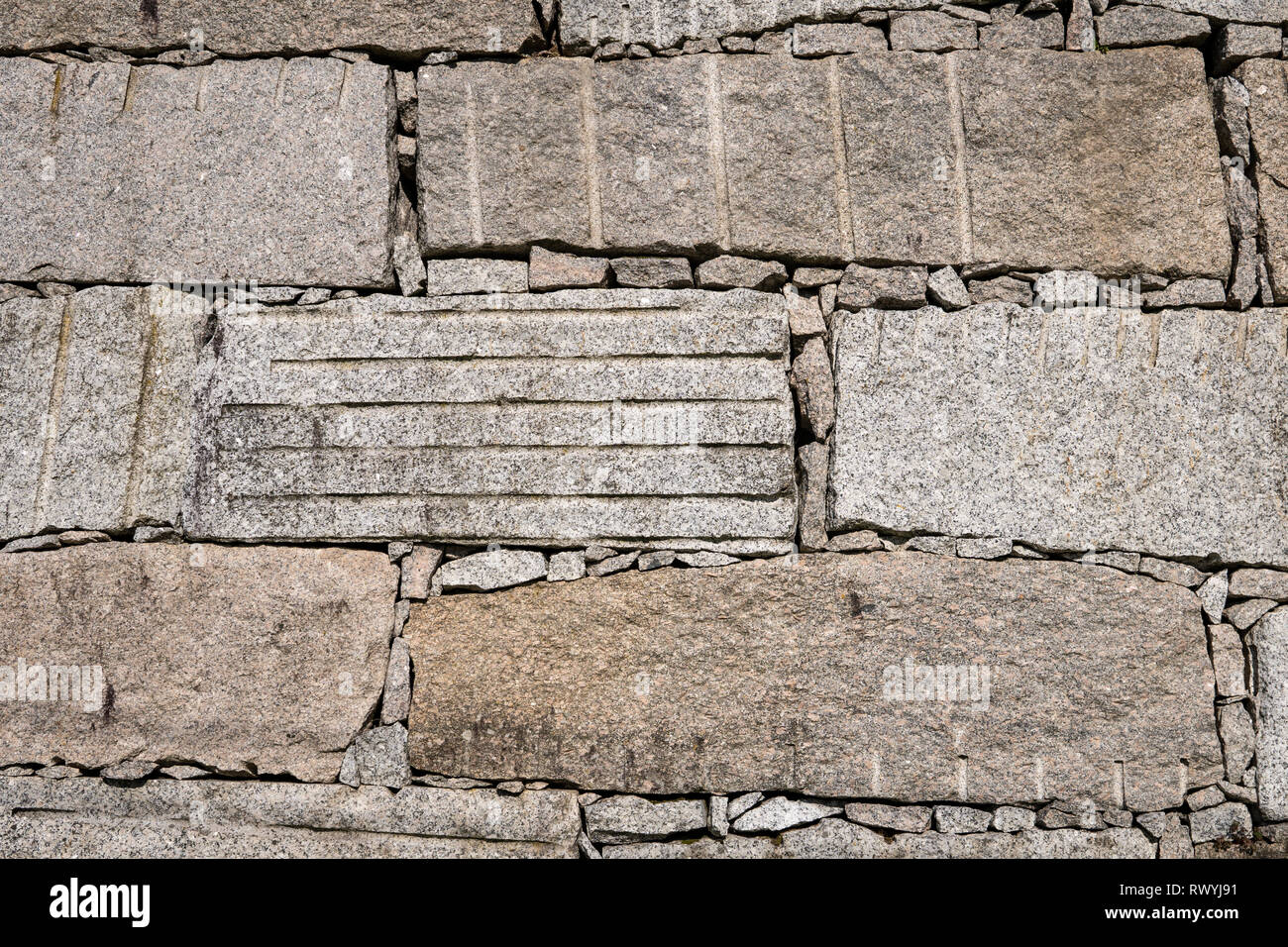 Block retaining wall made of big granite stones Dry masonry. Construction background Stock Photo