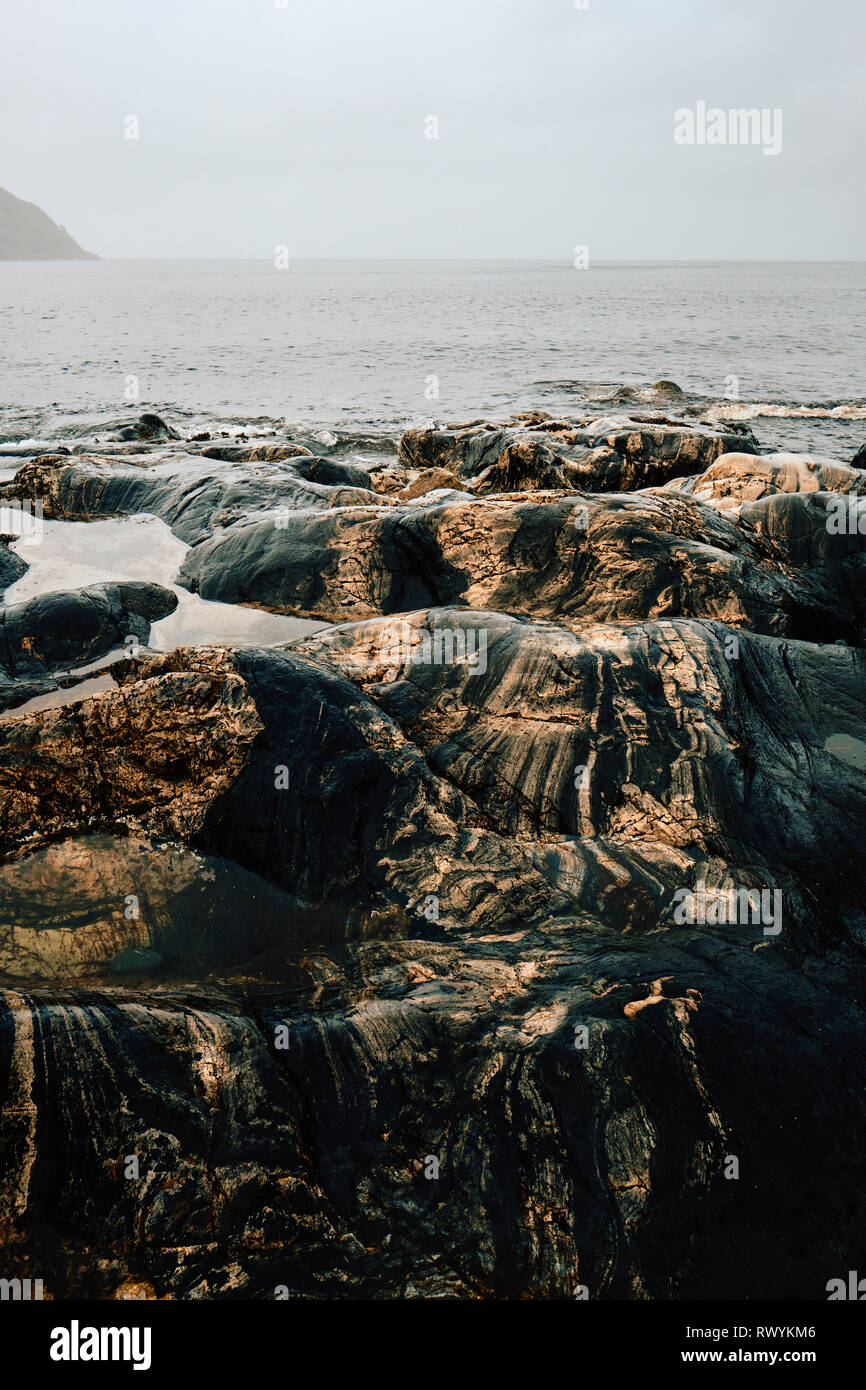The sea eroded colour striated rock on the coast at Oppedal, Måløy Vagsoy Norway. Stock Photo