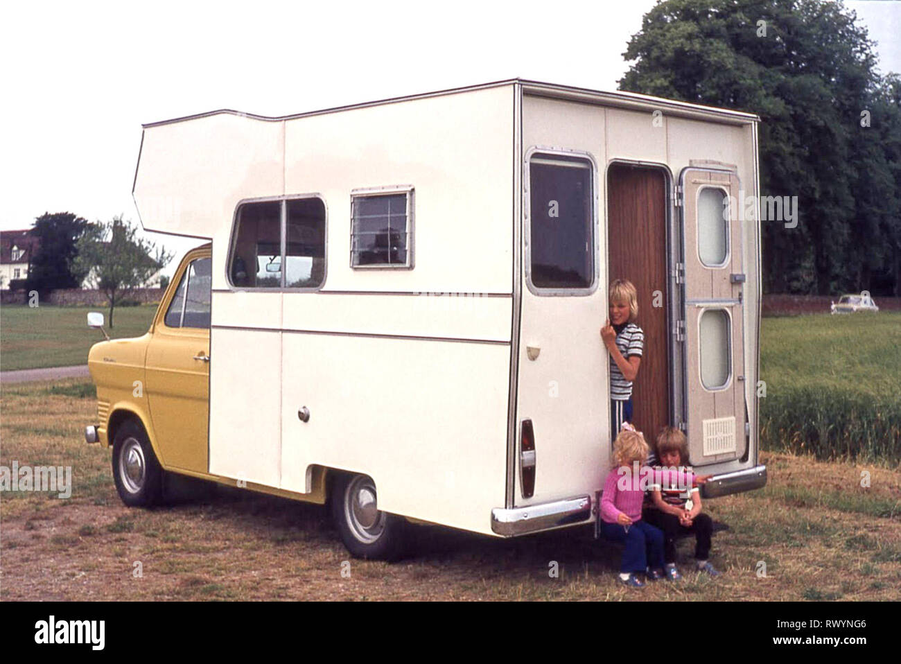 Purpose made RV camper van motorhome built 1970s on yellow Ford Transit chassis 3 young chidden 70s family holiday trip around East Anglia England UK two boys and one girl Stock Photo