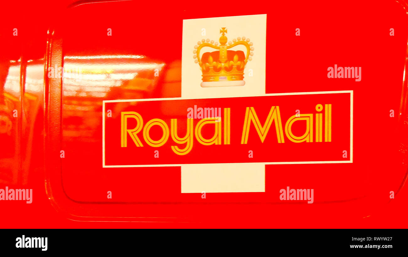 A modern royal mail carrier in London. It is a red van that carries