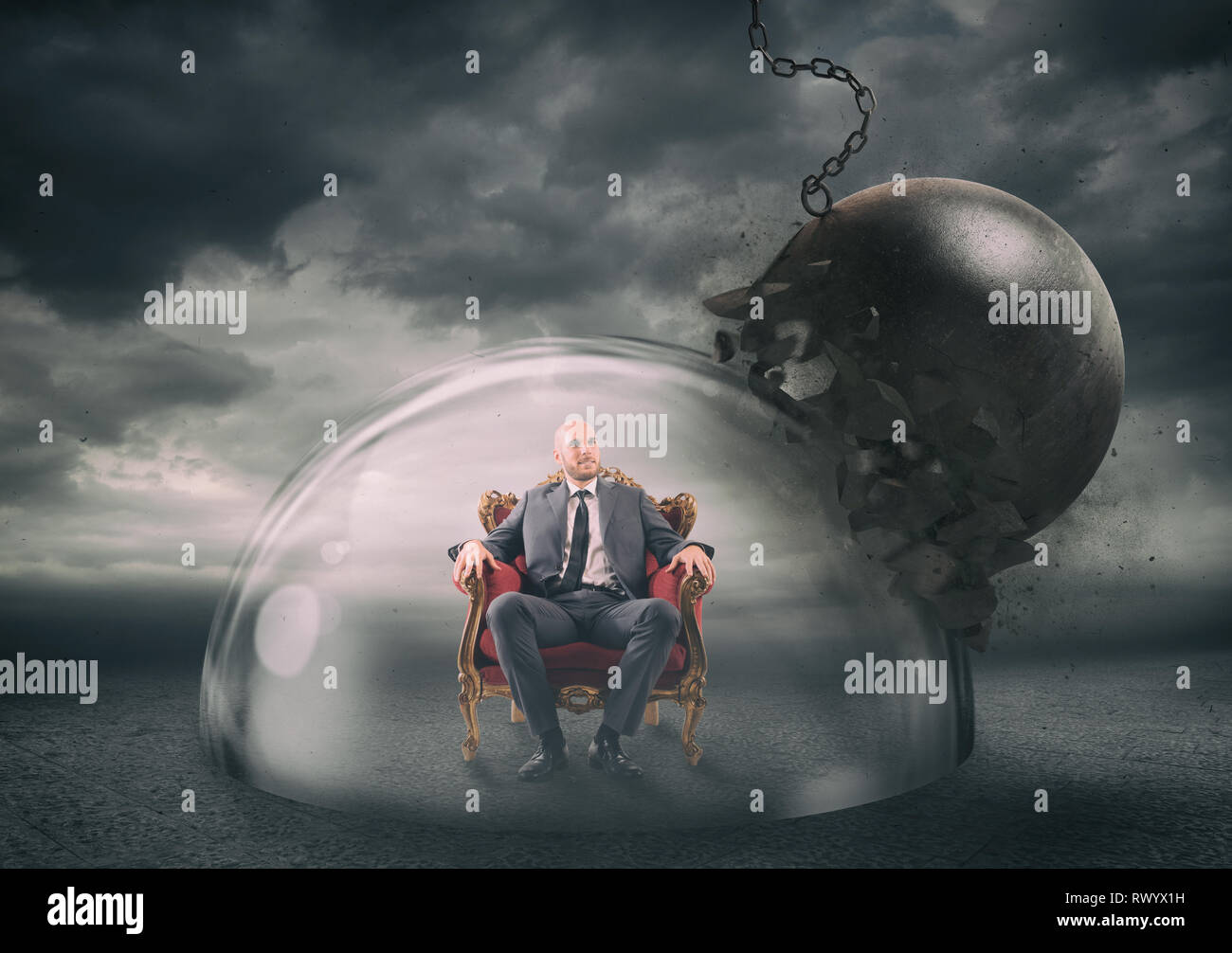 Businessman safely inside a shield dome during a storm that protects him from a wrecking ball. Protection and safety concept Stock Photo