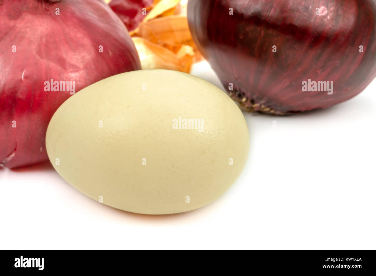 Fresh whole red onion, egg and dried onion skin isolated on white