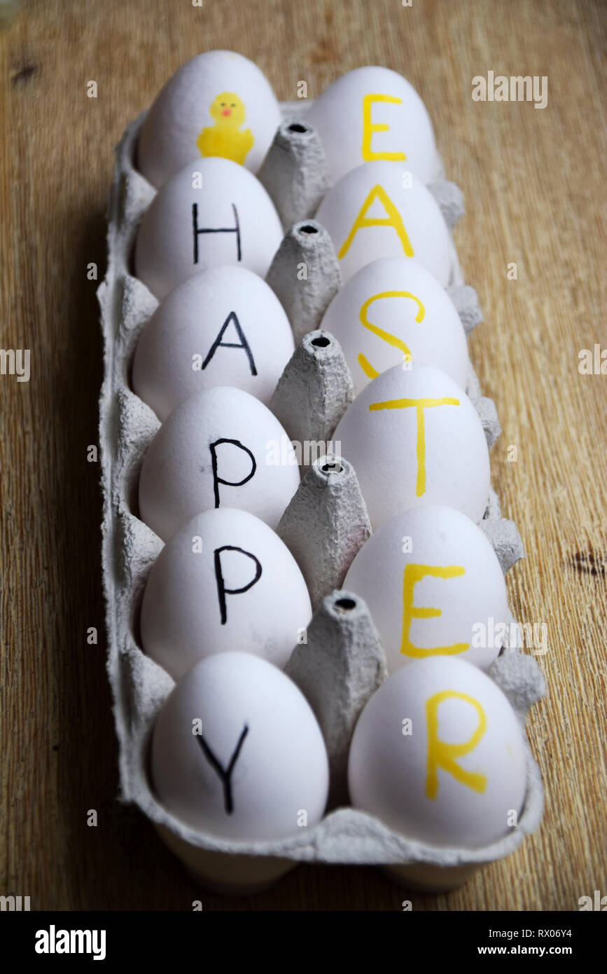 Happy Easter written on white eggs in a box Stock Photo