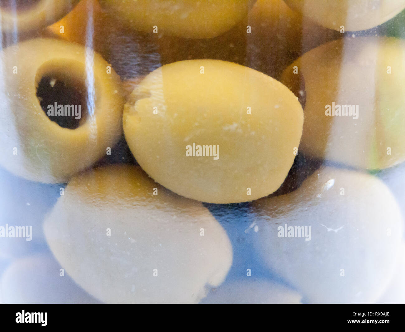 close up of green pitted olives inside jar food deli; essex; england